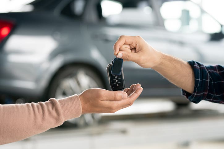 Car keys being handed from one person to another.