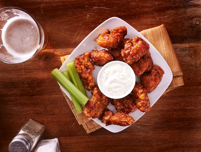 bbq buffalo chicken wings with beer ranch and celery shot from above