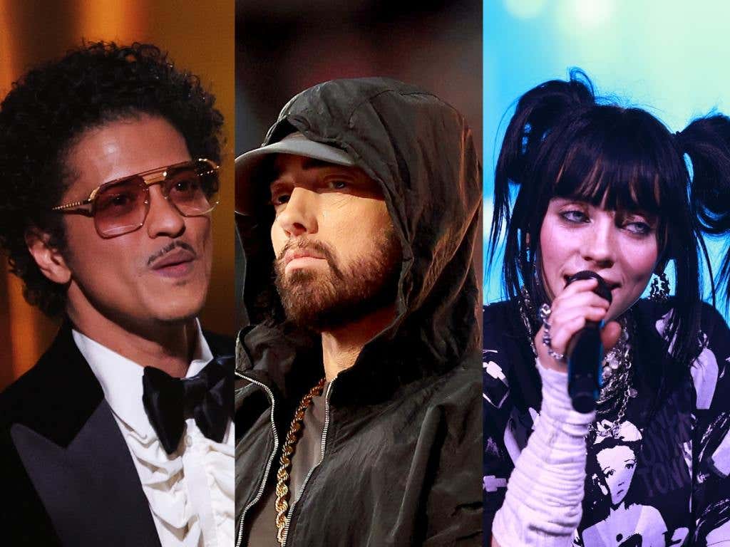 Bruno Mars at the 64th Annual GRAMMY Awards smiling wearing a suit and bowtie, Eminem performs during the Pepsi Super Bowl LVI Halftime Show facing right wearing a black hat and hoodie looking left, Billie Eilish performs onstage at The Kia Forum smiling looking right with a microphone in her hand.