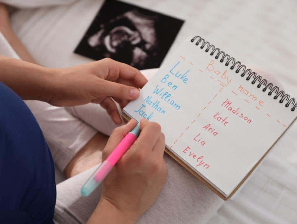 Pregnant woman with baby name list sitting on bed, closeup