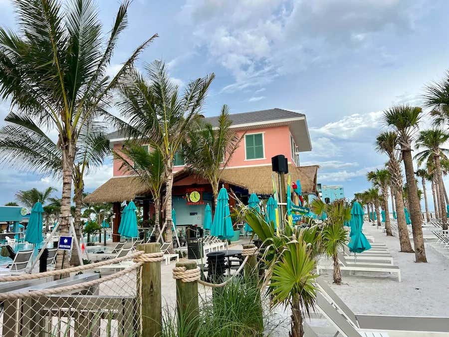 pink and bule building on the beach with palm trees and a swimming pool, Southwest Florida After The Hurricane