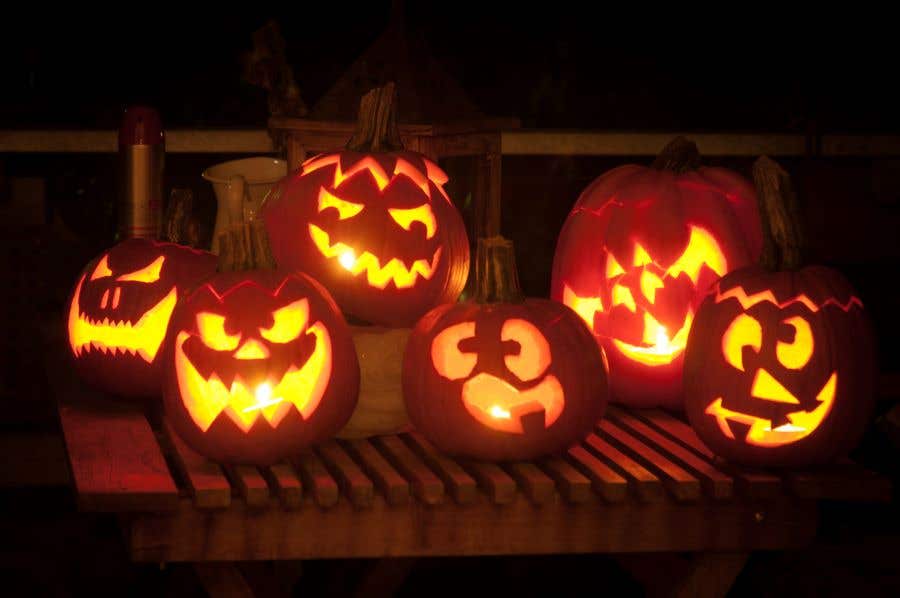 two rows of pumpkins carved with scary faces and lit with candles serving as Inspirations For Pumpkin Carving