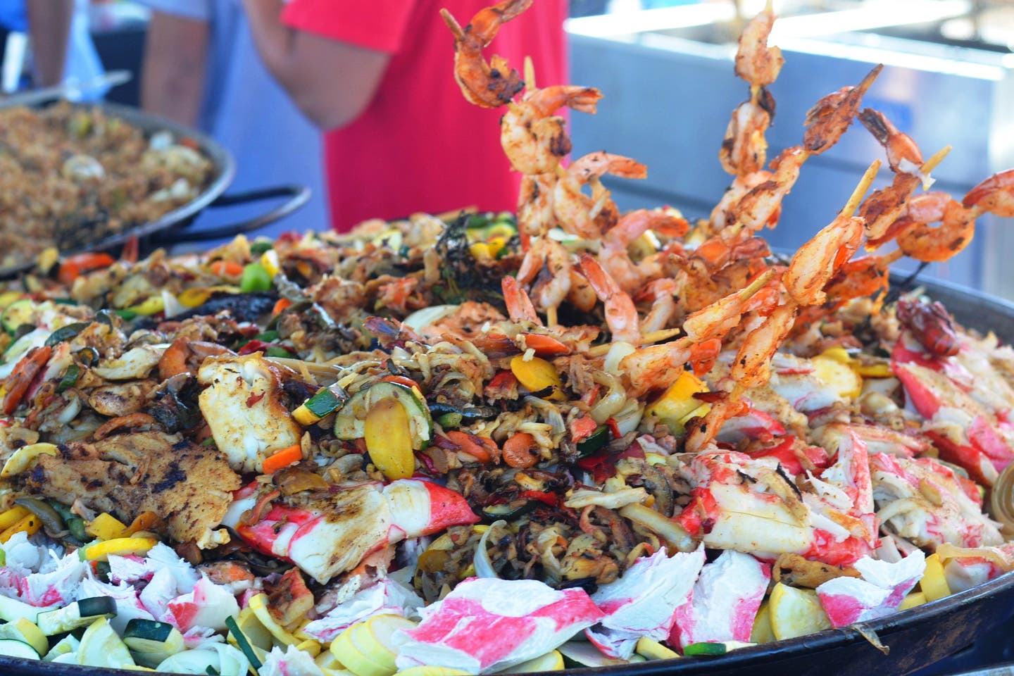 Seafood in large vessel, fresh seafood cooking at a festival.