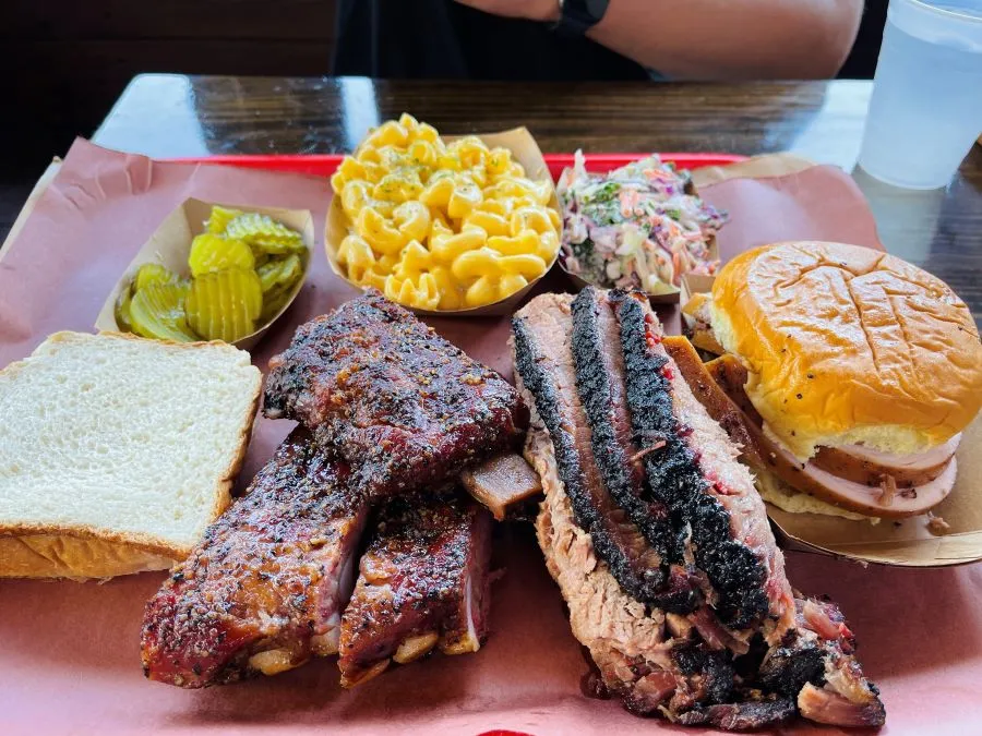 tray with BBQ ribs, BBQ sandwich, macaroni and cheese and pickles. 