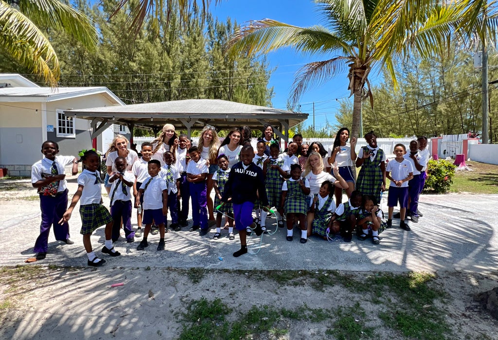 Students at schools in Bahamas with hooters girls deliver playground equipment