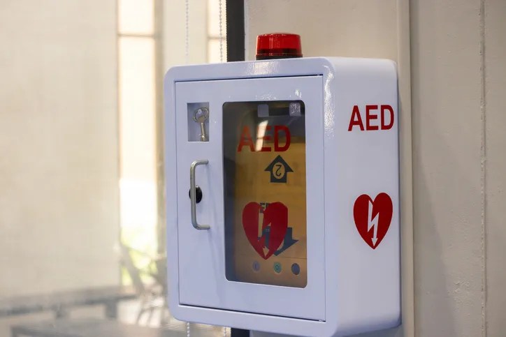 A white box with a red and yellow heart on it. The box is labeled AED